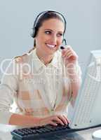Assertive businesswoman with headset on working at a computer