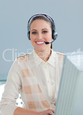 Charming businesswoman with headset on working at a computer