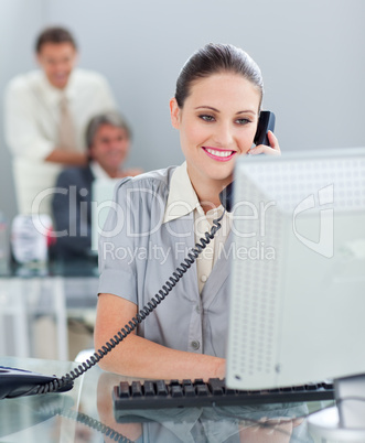 Confident businesswoman on phone working at a computer