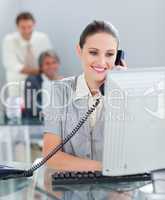 Confident businesswoman on phone working at a computer