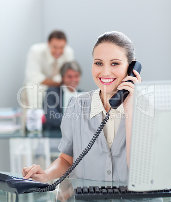 Charismatic businesswoman on phone working at a computer