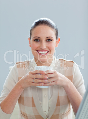 Delighted businesswoman drinking a coffee