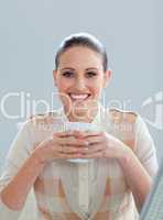 Delighted businesswoman drinking a coffee