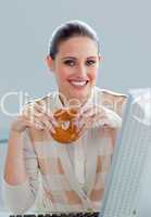 Young businesswoman eating a donut