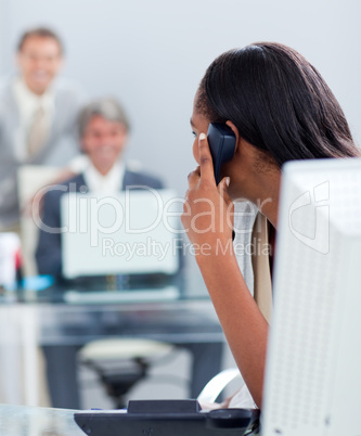 Afro-american businesswoman on phone at her desk