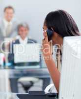 Afro-american businesswoman on phone at her desk