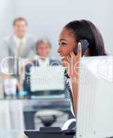 Smiling businesswoman on phone at her desk