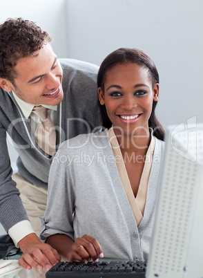 Young businessman helping his colleague at a computer