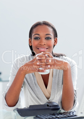 Attractive businesswoman drinking a coffee at her desk