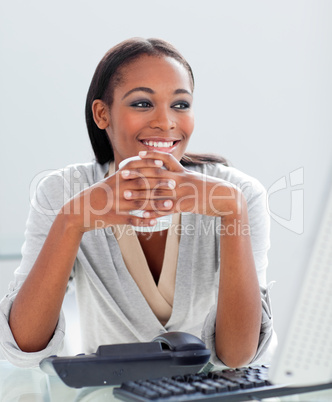 Smiling businesswoman drinking a coffee at her desk