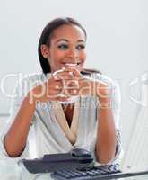 Smiling businesswoman drinking a coffee at her desk