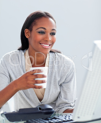 Confident businesswoman drinking a coffee at her desk