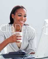 Confident businesswoman drinking a coffee at her desk