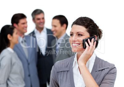 Caucasian woman talking on phone in front of her team