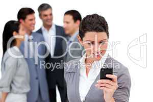 Attractive businesswoman looking at her cellphone in front of he