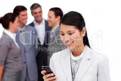 Asian businesswoman looking at her cellphone in front of her tea