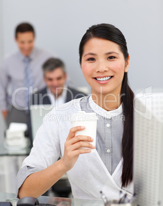 Asian woman drinking coffee in the office