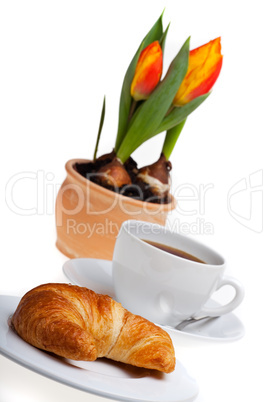 Croissant, eine Tasse Kaffee und Tulpe
