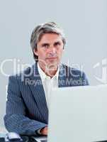 mature executive working at a laptop