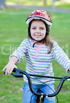 Joyful little girl riding a bike