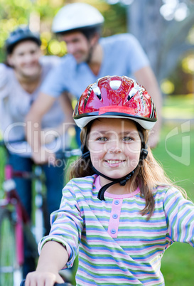 Smiling little girl riding a bike