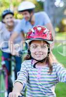 Smiling little girl riding a bike