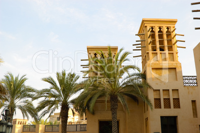 Arabic wind towers and palms during sunset, Dubai, UAE