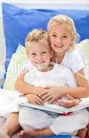 Blond brother and daughter reading books