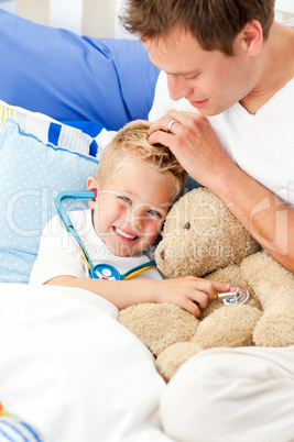 Smiling father and his sick son playing with a stethoscope