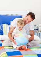 Enthusiastic father and his son looking at a terrestrial globe