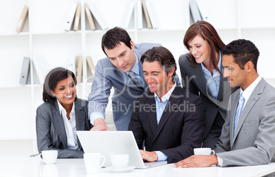Multi-cultural business team looking at a laptop