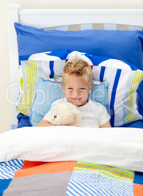 Adorable little boy lying in bed