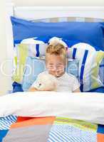 Adorable little boy lying in bed