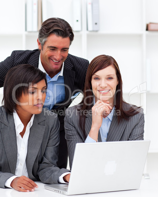 Positive businesswomen and their colleague working at a laptop