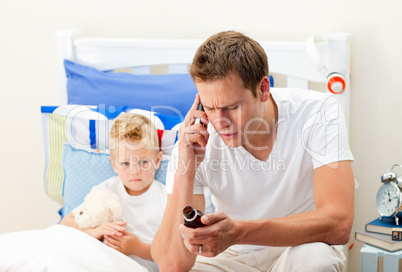 Attentive father on phone giving syrup to his son