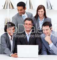 Cheerful business team looking at a laptop