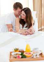 Intimate couple having breakfast lying in bed