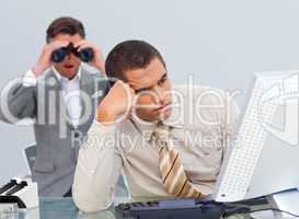 Young businessman getting bored and his manager looking through