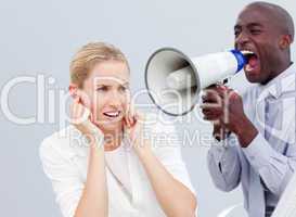 Angry businessman looking his colleague's computer through binoc