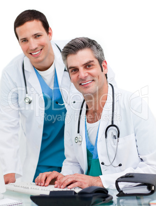 Two handsome male doctors working at a computer