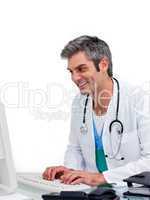 Smiling male doctor working at a computer