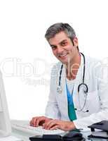 Mature male doctor working at a computer