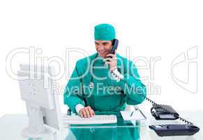 Positive surgeon on phone working at a computer