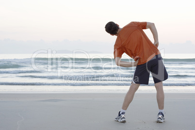 Jogger dehnt sich am Strand