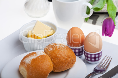 Eier, Brötchen, Butter und Kaffee auf weißem Hintergrund