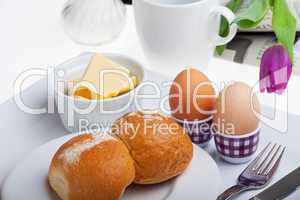 Eier, Brötchen, Butter und Kaffee auf weißem Hintergrund
