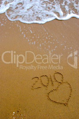 Year 2010 written on the sand