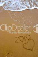 Year 2010 written on the sand