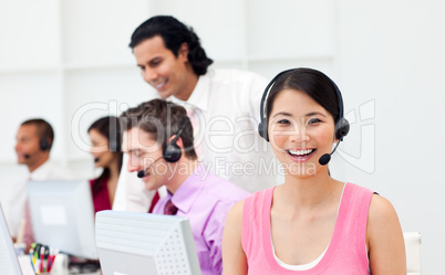 Portrait of an Asian customer agent and her team