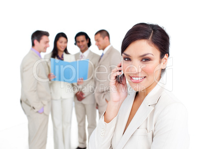 Portrait of a brunette businesswoman on phone with her team